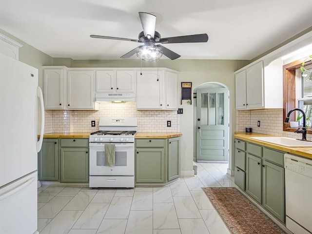 kitchen with green cabinets, butcher block countertops, white appliances, and a sink