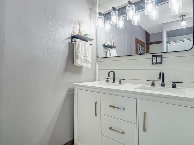 full bath with double vanity and a textured wall