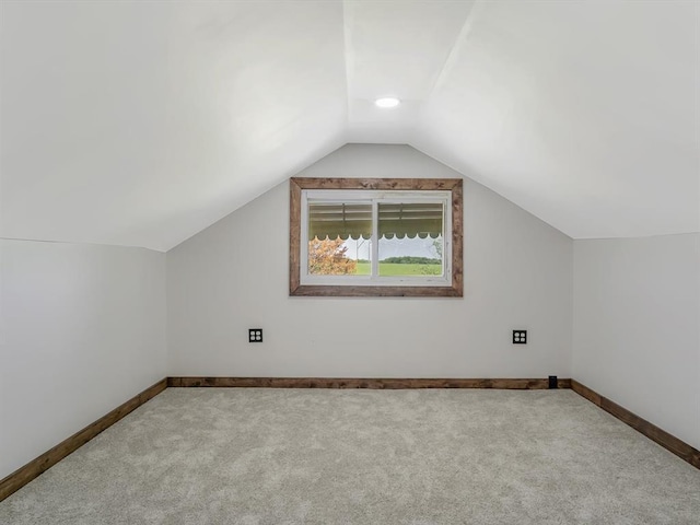 additional living space featuring carpet, vaulted ceiling, and baseboards