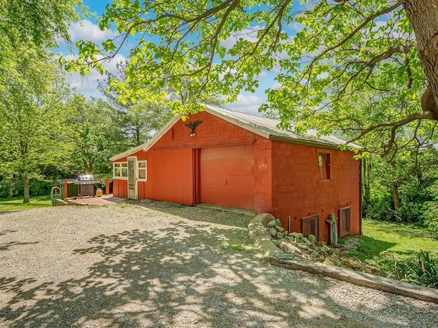view of home's exterior with a garage, an outdoor structure, and metal roof