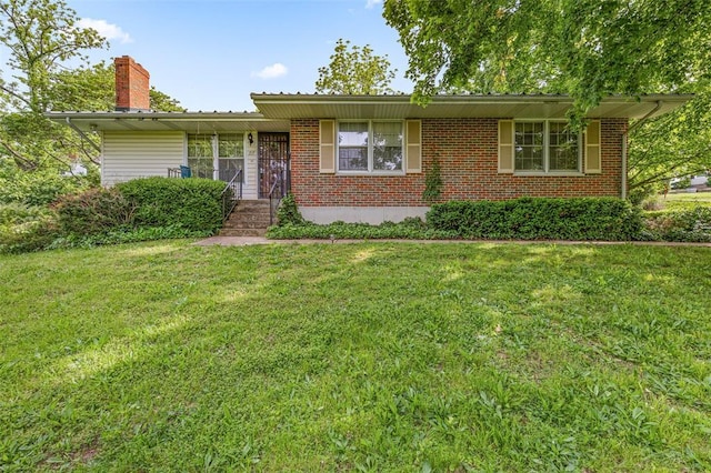 717 W Clement St, De Soto, MO 63020 - view of front of house with a front lawn, a chimney, and brick siding
