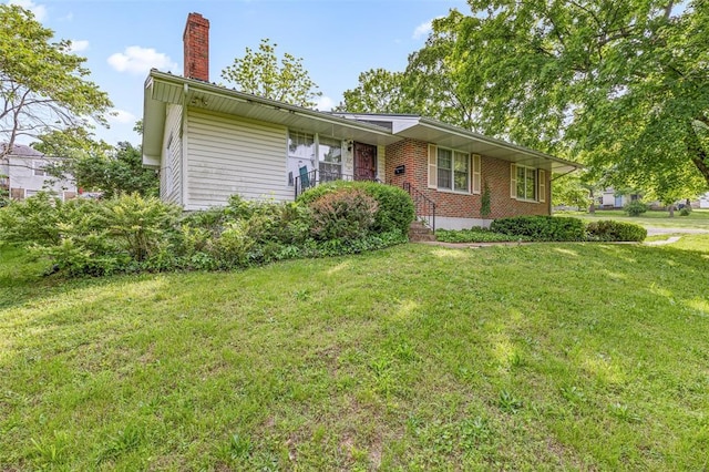 717 W Clement St, De Soto, MO 63020 - view of front of house with a front lawn, a chimney, and brick siding