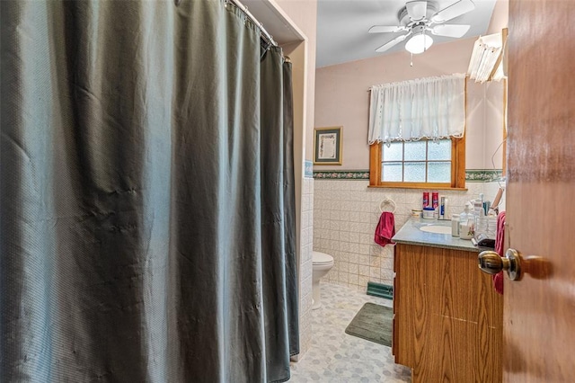 717 W Clement St, De Soto, MO 63020 - bathroom featuring tile walls, a wainscoted wall, ceiling fan, toilet, and vanity