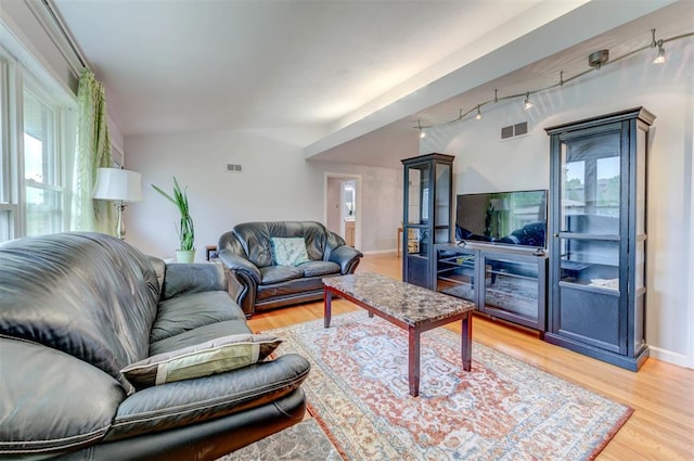 living room with rail lighting, light wood-style floors, and baseboards