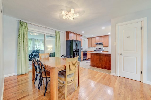 dining space featuring light wood-type flooring, a chandelier, baseboards, and recessed lighting