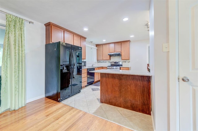kitchen featuring black appliances, light countertops, under cabinet range hood, recessed lighting, and light wood-style floors
