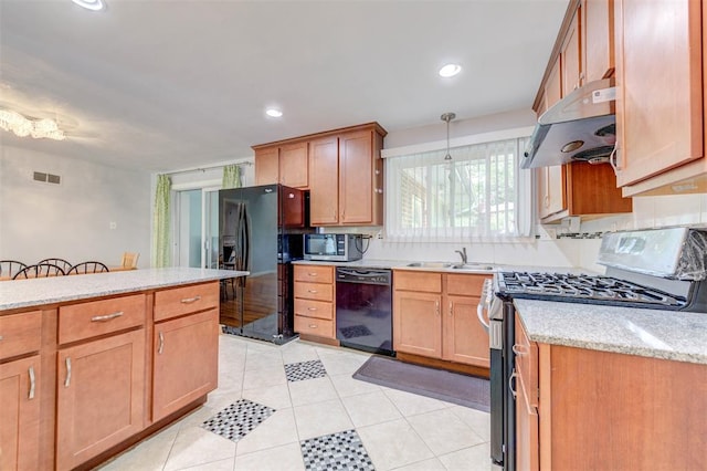 kitchen with black appliances, under cabinet range hood, a sink, light tile patterned flooring, and light stone countertops