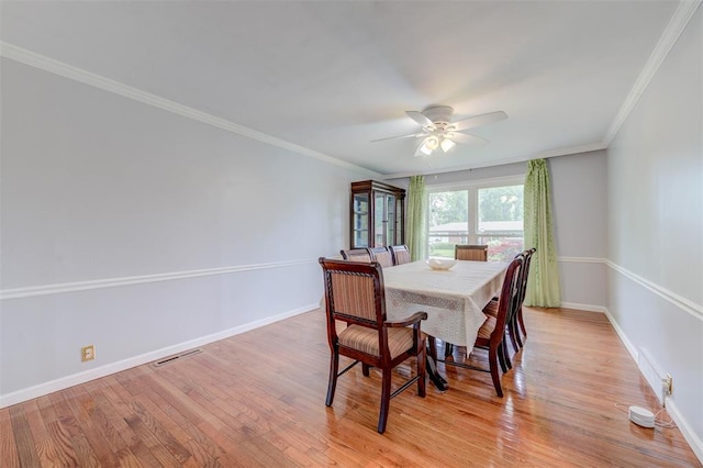 dining room featuring a ceiling fan, light wood-type flooring, baseboards, and ornamental molding