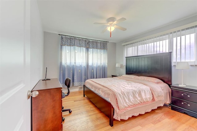 bedroom featuring multiple windows, wood finished floors, ceiling fan, and baseboards