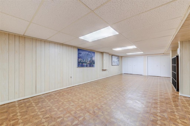 spare room featuring a drop ceiling, parquet flooring, and baseboards