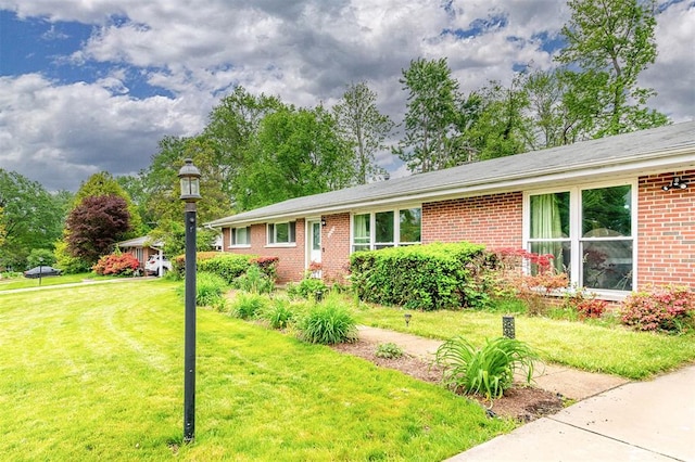 ranch-style house with brick siding and a front yard
