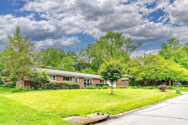 ranch-style home featuring brick siding and a front yard