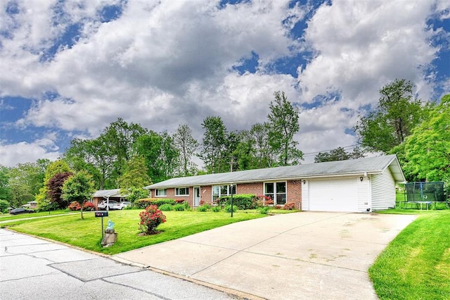 ranch-style home with a trampoline, driveway, an attached garage, brick siding, and a front lawn
