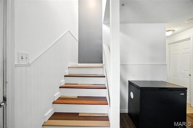 8544 Lake Dr, Cedar Hill, MO 63016 - staircase with wainscoting, a textured ceiling, and wood finished floors