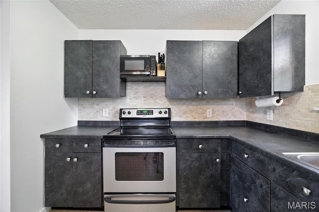 8544 Lake Dr, Cedar Hill, MO 63016 - kitchen with appliances with stainless steel finishes, dark countertops, backsplash, and a textured ceiling