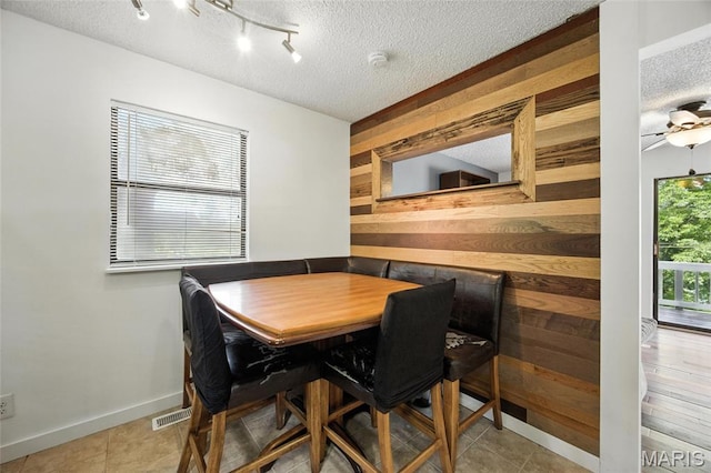 8544 Lake Dr, Cedar Hill, MO 63016 - dining room with a textured ceiling, wooden walls, and tile patterned floors