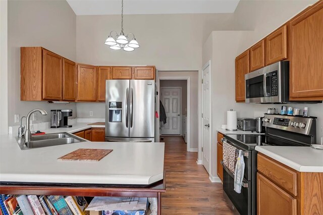 140 Glen Forest Dr, Troy, MO 63379 - kitchen featuring stainless steel appliances, a sink, a chandelier, light countertops, and wood finished floors