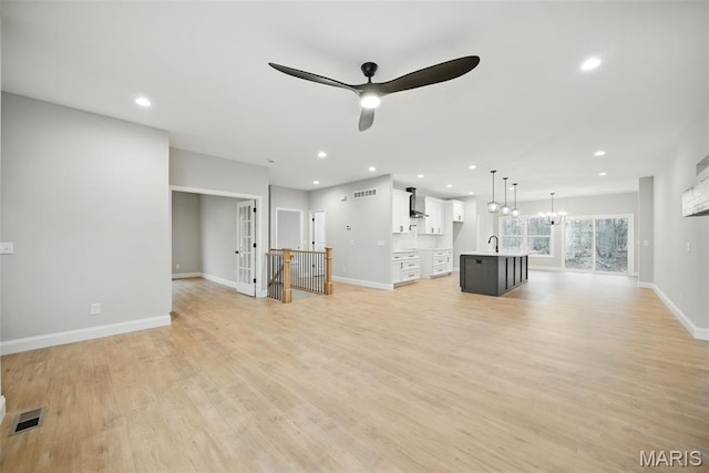 31998 Fairway Dr N, Foristell, MO 63348 - unfurnished living room with ceiling fan, recessed lighting, light wood-style floors, and a chandelier