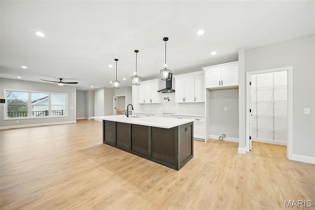 31998 Fairway Dr N, Foristell, MO 63348 - kitchen with white cabinets, light countertops, light wood finished floors, a kitchen island with sink, and ceiling fan