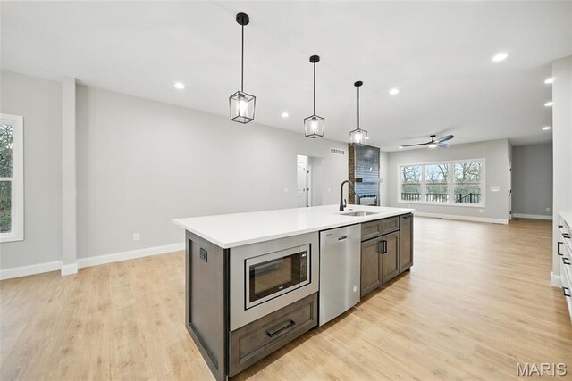 31998 Fairway Dr N, Foristell, MO 63348 - kitchen with appliances with stainless steel finishes, open floor plan, light countertops, ceiling fan, and light wood-style flooring