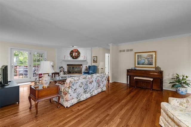 308 Wildbrier Dr, Ballwin, MO 63011 - living area with wood finished floors, a brick fireplace, and ornamental molding