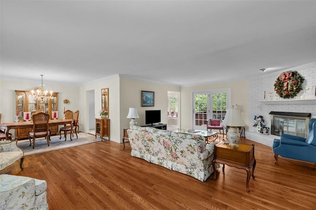 308 Wildbrier Dr, Ballwin, MO 63011 - living room featuring wood finished floors, a chandelier, crown molding, and a fireplace