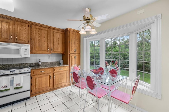 308 Wildbrier Dr, Ballwin, MO 63011 - kitchen with white appliances, brown cabinetry, tasteful backsplash, ceiling fan, and light tile patterned floors