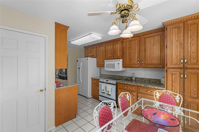 308 Wildbrier Dr, Ballwin, MO 63011 - kitchen with white appliances, brown cabinetry, light tile patterned floors, and a ceiling fan