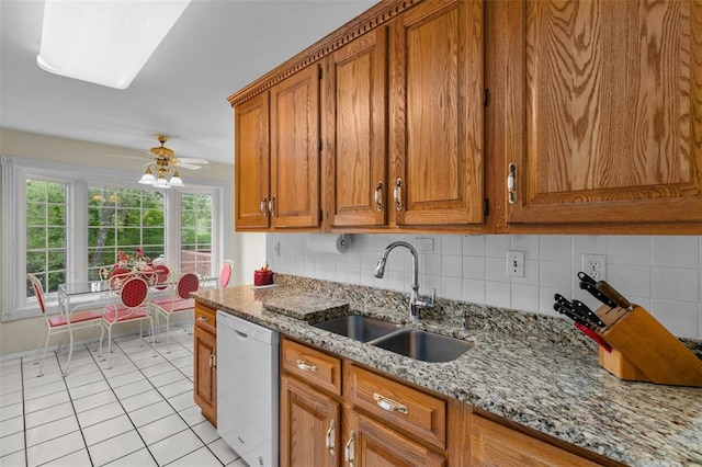 308 Wildbrier Dr, Ballwin, MO 63011 - kitchen featuring white dishwasher, a sink, brown cabinetry, and light stone countertops