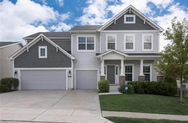 craftsman-style home featuring driveway, a front yard, and an attached garage