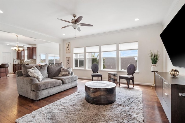 living room with a chandelier, crown molding, a ceiling fan, dark wood-style flooring, and recessed lighting
