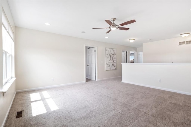 unfurnished room with light carpet, healthy amount of natural light, a ceiling fan, and recessed lighting
