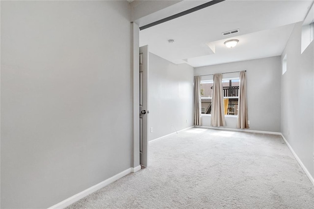 empty room featuring carpet and baseboards