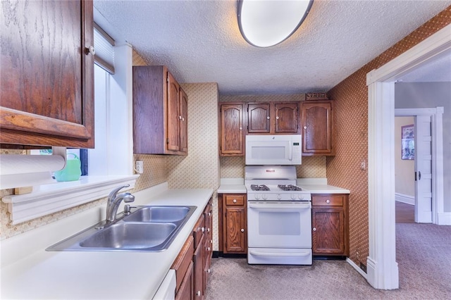 4526 Gibson Ave, Saint Louis, MO 63110 - kitchen featuring white appliances, a sink, carpet floors, wallpapered walls, and light countertops