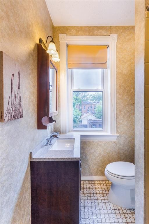4526 Gibson Ave, Saint Louis, MO 63110 - bathroom featuring toilet, tile patterned flooring, vanity, and baseboards