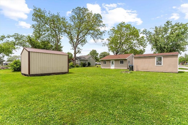 view of grassy yard featuring a storage unit and an outbuilding