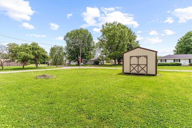 view of grassy yard featuring a storage shed and an outbuilding