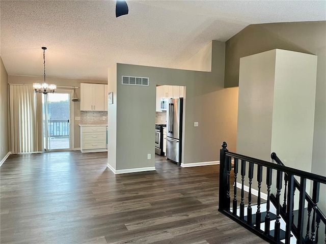 3060 Laurel Village Cir, Saint Peters, MO 63376 - kitchen with appliances with stainless steel finishes, white cabinets, a chandelier, dark wood-style floors, and tasteful backsplash