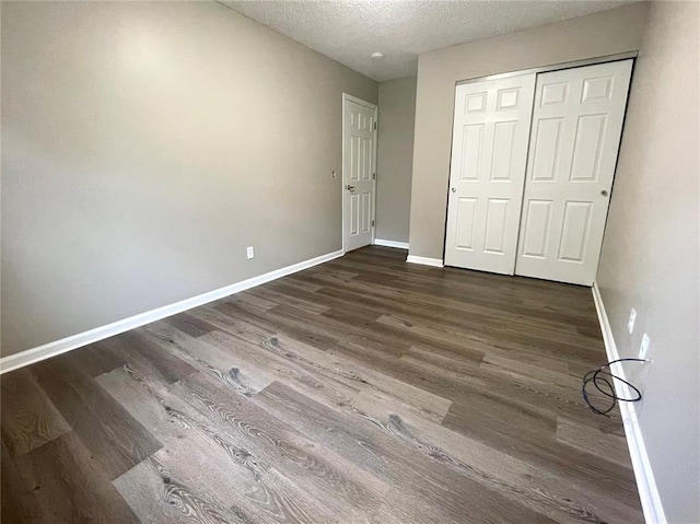 3060 Laurel Village Cir, Saint Peters, MO 63376 - unfurnished bedroom featuring dark wood finished floors, baseboards, a textured ceiling, and a closet