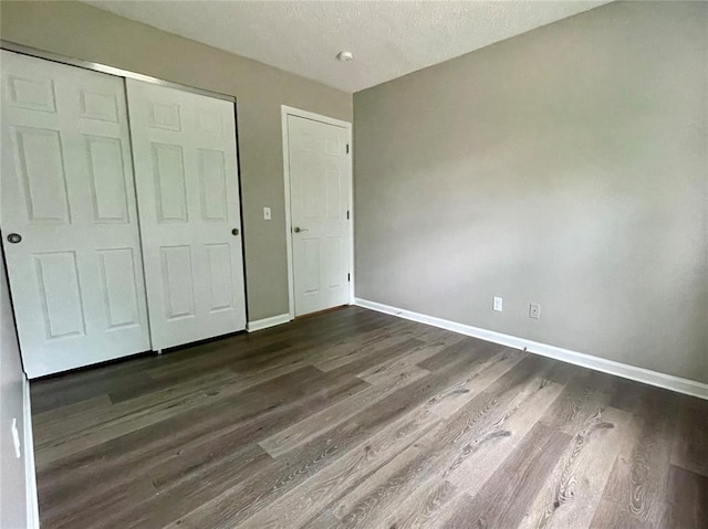 3060 Laurel Village Cir, Saint Peters, MO 63376 - unfurnished bedroom with dark wood finished floors, baseboards, a closet, and a textured ceiling