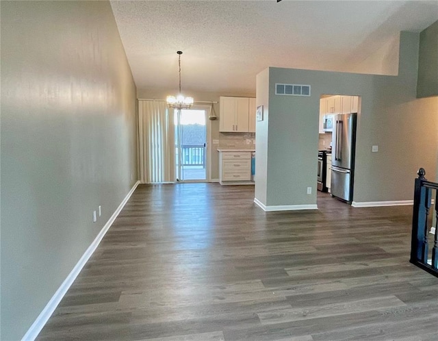 3060 Laurel Village Cir, Saint Peters, MO 63376 - unfurnished living room with dark wood-type flooring, a chandelier, baseboards, and vaulted ceiling