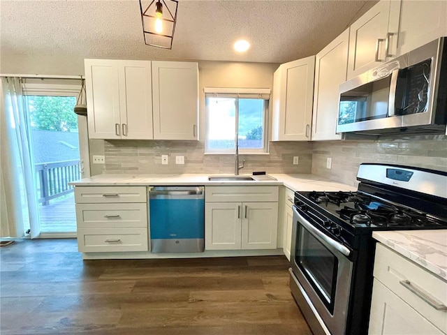 3060 Laurel Village Cir, Saint Peters, MO 63376 - kitchen with appliances with stainless steel finishes, a sink, a textured ceiling, white cabinetry, and backsplash