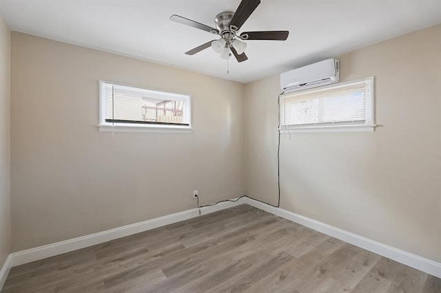 11893 Bridgevale Ave, Saint Louis, MO 63138 - unfurnished room featuring an AC wall unit, light wood-style floors, baseboards, and ceiling fan