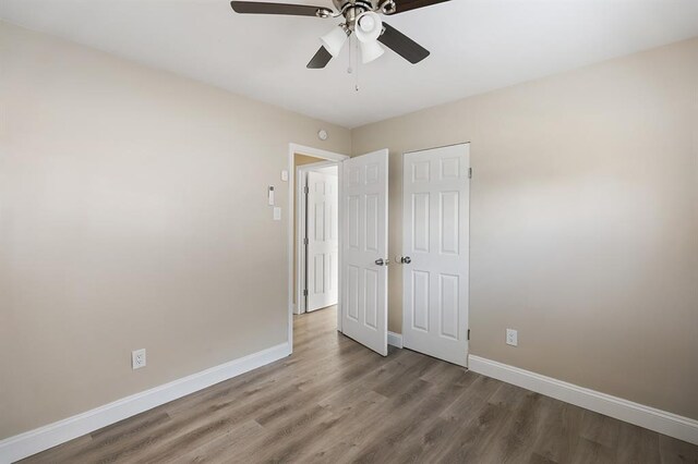 11893 Bridgevale Ave, Saint Louis, MO 63138 - unfurnished bedroom featuring baseboards, wood finished floors, and a ceiling fan