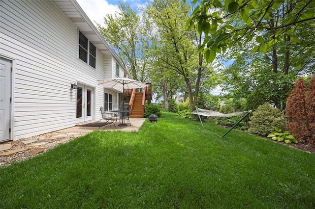 view of green lawn with french doors and a patio area