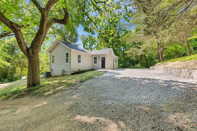 view of front of property with gravel driveway and central AC