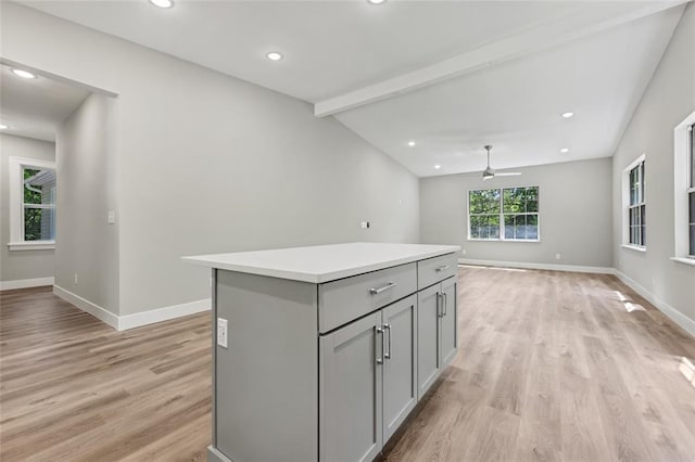 kitchen with gray cabinetry, light wood-type flooring, ceiling fan, a center island, and baseboards