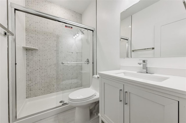 full bath featuring toilet, a stall shower, and vanity