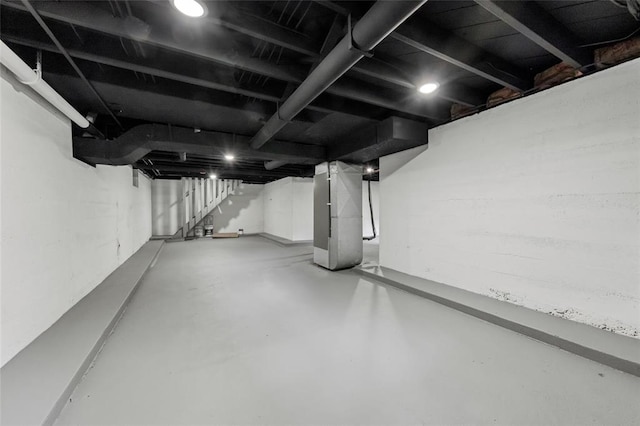 unfinished basement featuring stairs and heating unit