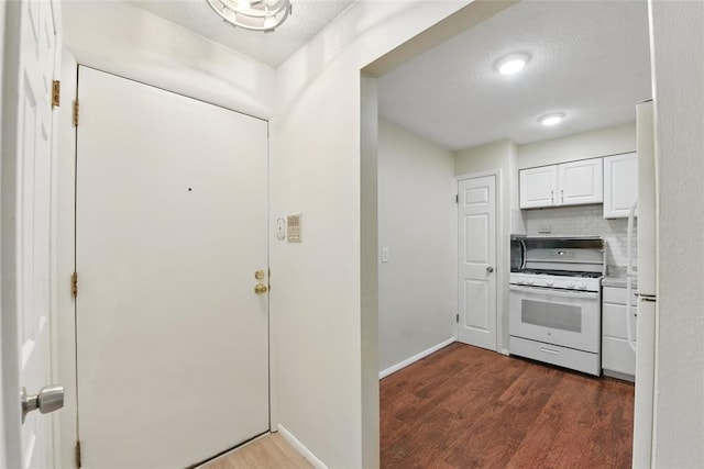 444 N Clay Ave Unit 2N, Kirkwood, MO 63122 - kitchen with white range with gas cooktop, dark wood-style flooring, white cabinets, a textured ceiling, and baseboards